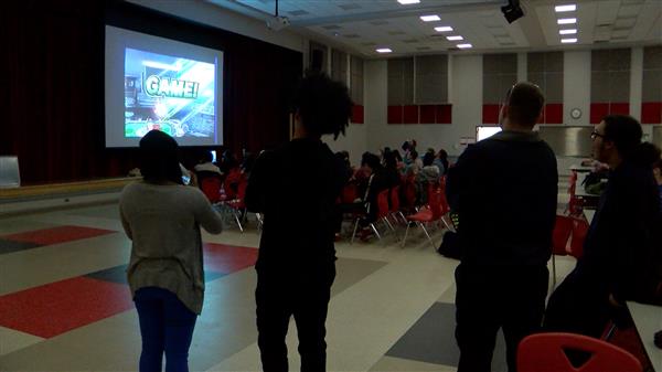  Students, staff, spectators watch esports video game tournament on projector